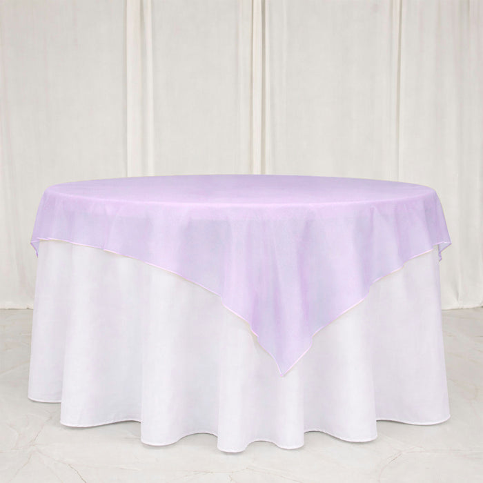 Lavender sheer table overlay on round white table with draped backdrop