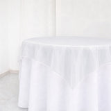 White round table with sheer tablecloth in a bright minimalist room