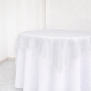 White round table with sheer tablecloth in a bright minimalist room