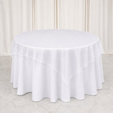 Round table with white layered tablecloth and elegant draped backdrop