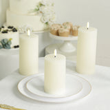 Three elegant white pillar candles on a table with a decorative plate.