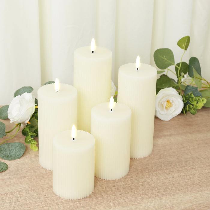Set of six ivory pillar candles with flickering flames and textured surfaces.