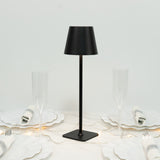 Modern black table lamp on a dining table with elegant glassware.