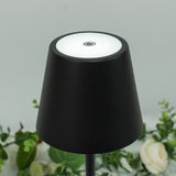 Black lamp with a round light top and power button.
