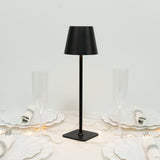 Black table lamp on a dining table with elegant dishware and glasses.