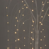 Illuminated decorative tree with twinkling lights against a dark background.