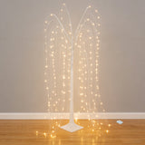 Illuminated decorative tree with cascading lights on a plain backdrop.