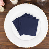 Navy blue napkins stacked on a decorative plate.
