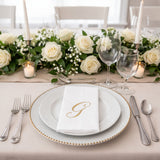 Elegant table setting with white roses and gold accents.