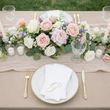 Elegant table setting with floral centerpiece and gold-accented plates.