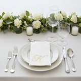 Elegant table setting with roses, glassware, and personalized napkin.