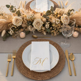 Elegant dining setup with gold accents and floral centerpiece.