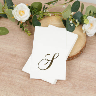 Elegant napkins with a gold initial "S" design on a wooden surface.