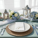 Elegant table setting with floral arrangements, candles, and decorative plates.