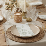 Elegant dining table set with floral napkin, glassware, and candlelight ambiance.