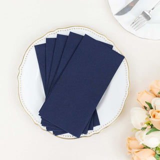 Navy blue napkins on an elegant plate with a floral arrangement