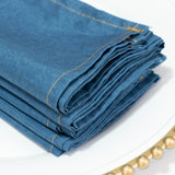 Folded blue denim fabric with visible stitching details.