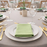 Elegant table setting with green napkin and gold-accented dinnerware.