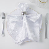 Elegant white napkin with silver embellishments on a plate