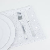 Elegant silver cutlery on a sparkling white tablecloth.