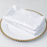 Sparkly white napkins stacked on a decorative plate.