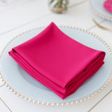 Stack of vibrant pink napkins on a decorative plate.