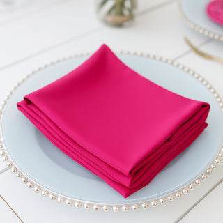 Stack of vibrant pink napkins on a decorative plate.