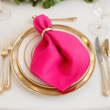 Pink napkin elegantly styled on a gold-rimmed plate setting.