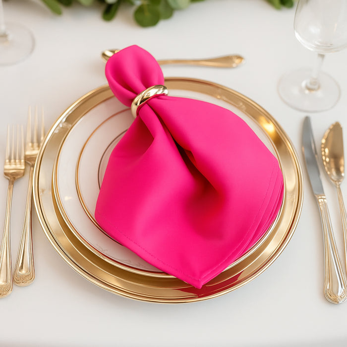 Pink napkin elegantly styled on a gold-rimmed plate setting.