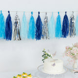 Blue and silver tassel garland above a cake and floral arrangement.