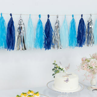 Blue and silver tassel garland above a cake and floral arrangement.