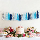 Decorative tassel garland in blue and silver at a festive dessert table with flowers.