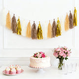 Birthday cake with cupcakes, flowers, and a decorative tassel garland.