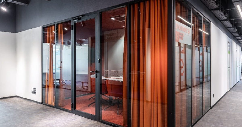 Glass meeting room with orange curtains