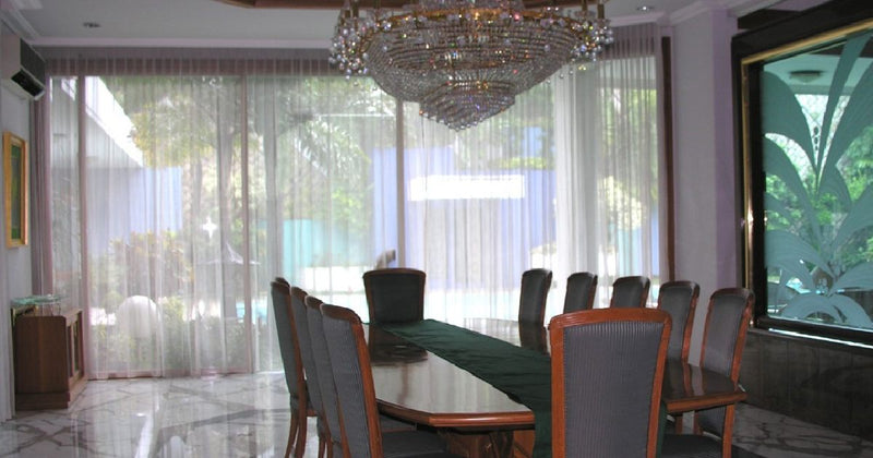 Dining room with sheer curtains and chandelier
