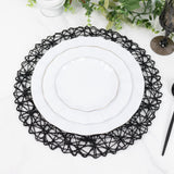 Elegant white plates with gold trim on a decorative black lace placemat.