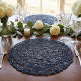Elegant table setting with white roses, crystal glasses, and navy placemats
