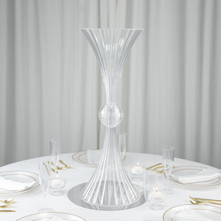 Elegant clear glass vase centerpiece on a dining table set for a formal meal.