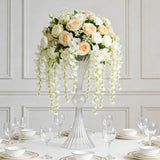 Elegant floral centerpiece with roses and orchids on a dining table.