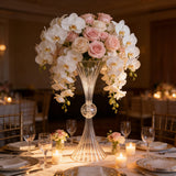 Elegant floral centerpiece with roses and orchids in a crystal vase.