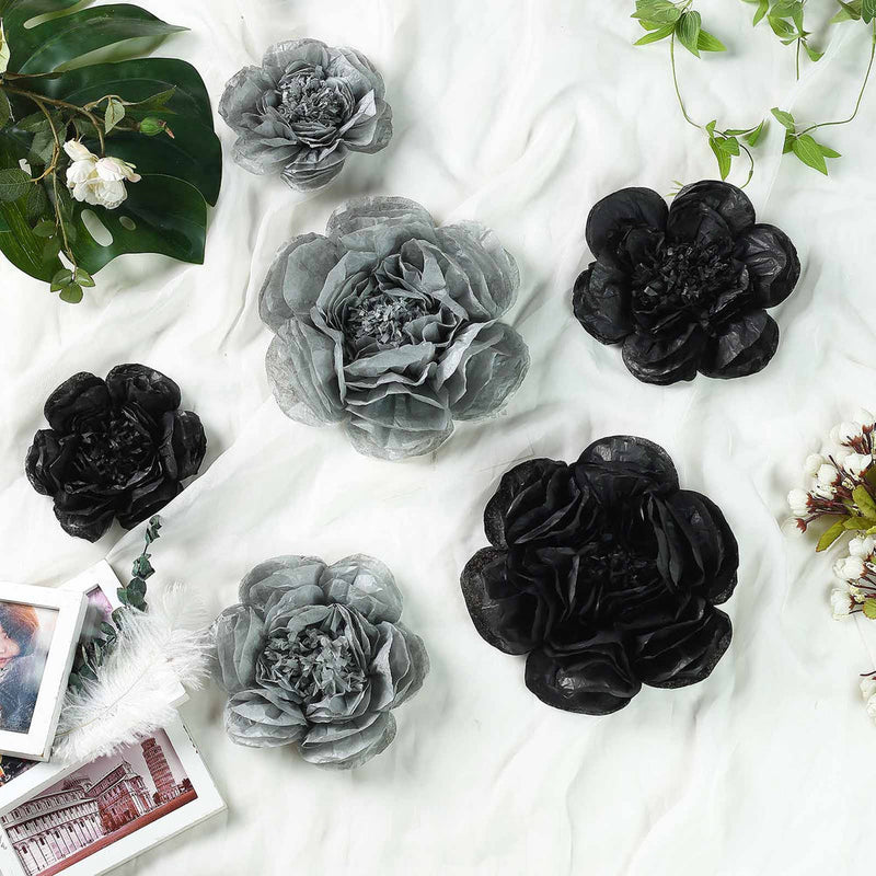 Gray and black paper flowers with greenery on white fabric