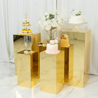 Elegant gold display pedestals featuring cakes and desserts in a styled setting.