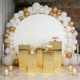 Decorative dessert display with gold elements and a balloon arch backdrop.