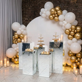 Elegant dessert display with mirrored stands and a festive balloon backdrop.