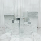 Mirrored cube display pedestals arranged in a white studio room