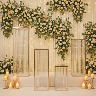 Elegant glass display pedestals adorned with floral backdrop and soft lighting.