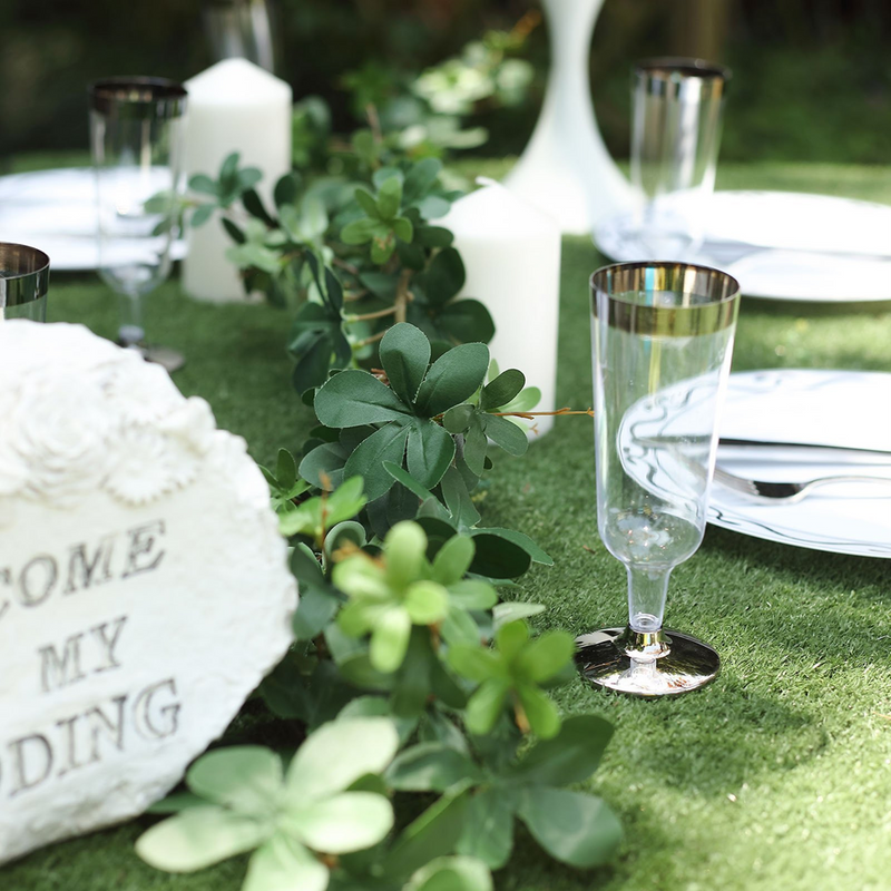 Outdoor table setting with greenery and glassware