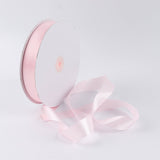 Pink satin ribbon spool isolated on white background