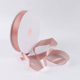 Pink satin ribbon spool on white background