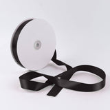 Black satin ribbon spool on white background